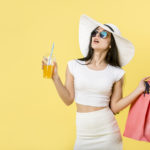 Lady holding a shopping bag whilst drinking juice