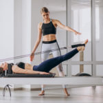 Pilates instructor guiding woman in exercises after her 3D cavitation treatment as part of her professional aftercare service.