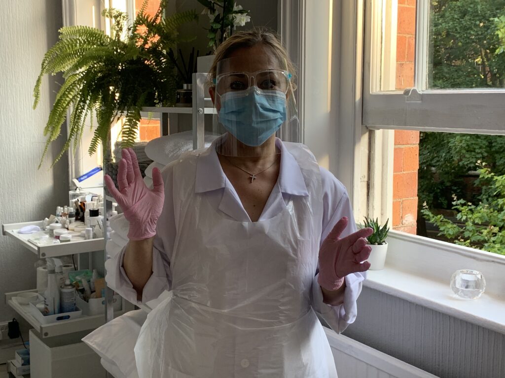 Tatiana, at 3D Ultimate wearing her Covid-19 PPE, including a mask, visor, gloves and apron in the clinic room.