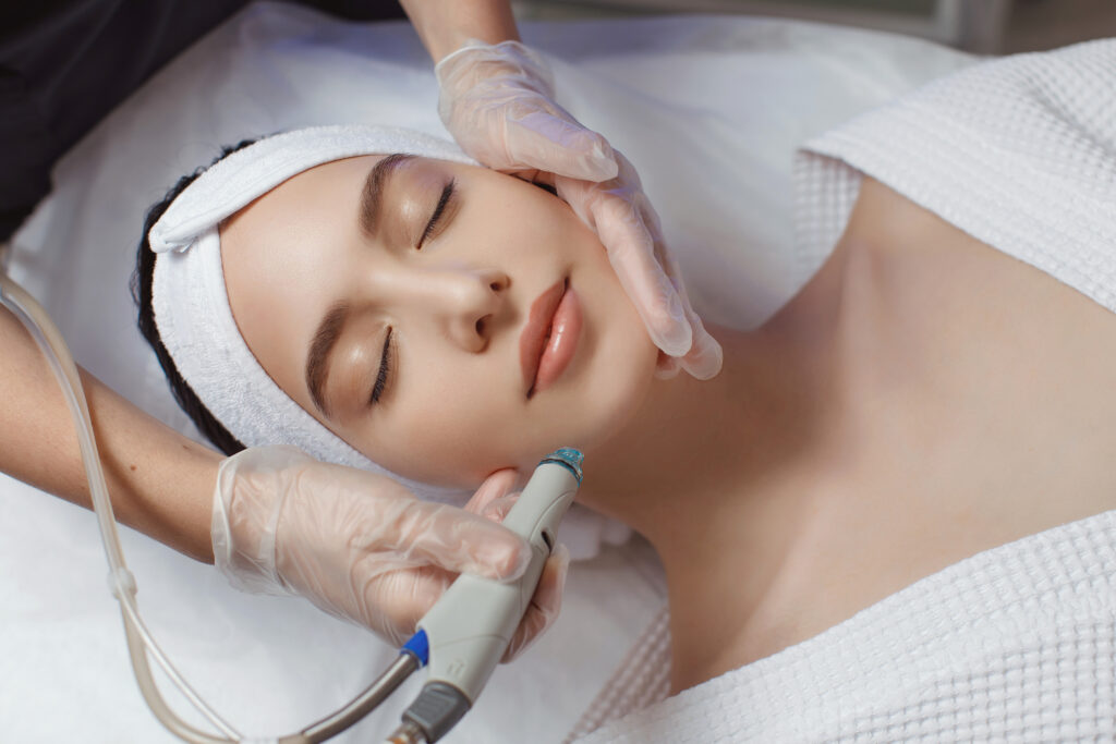 Side view of woman receiving bespoke treatments therapy on forehead. Hydrafacial procedure